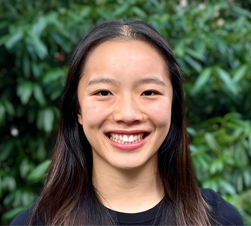 Headshot of Harvard math preceptor Sarah Chin smiling and looking at the camera on a background of green foliage.