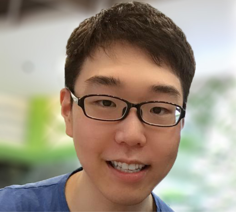 A close-up of a male PhD math student with short dark hair and glasses looking at the camera.